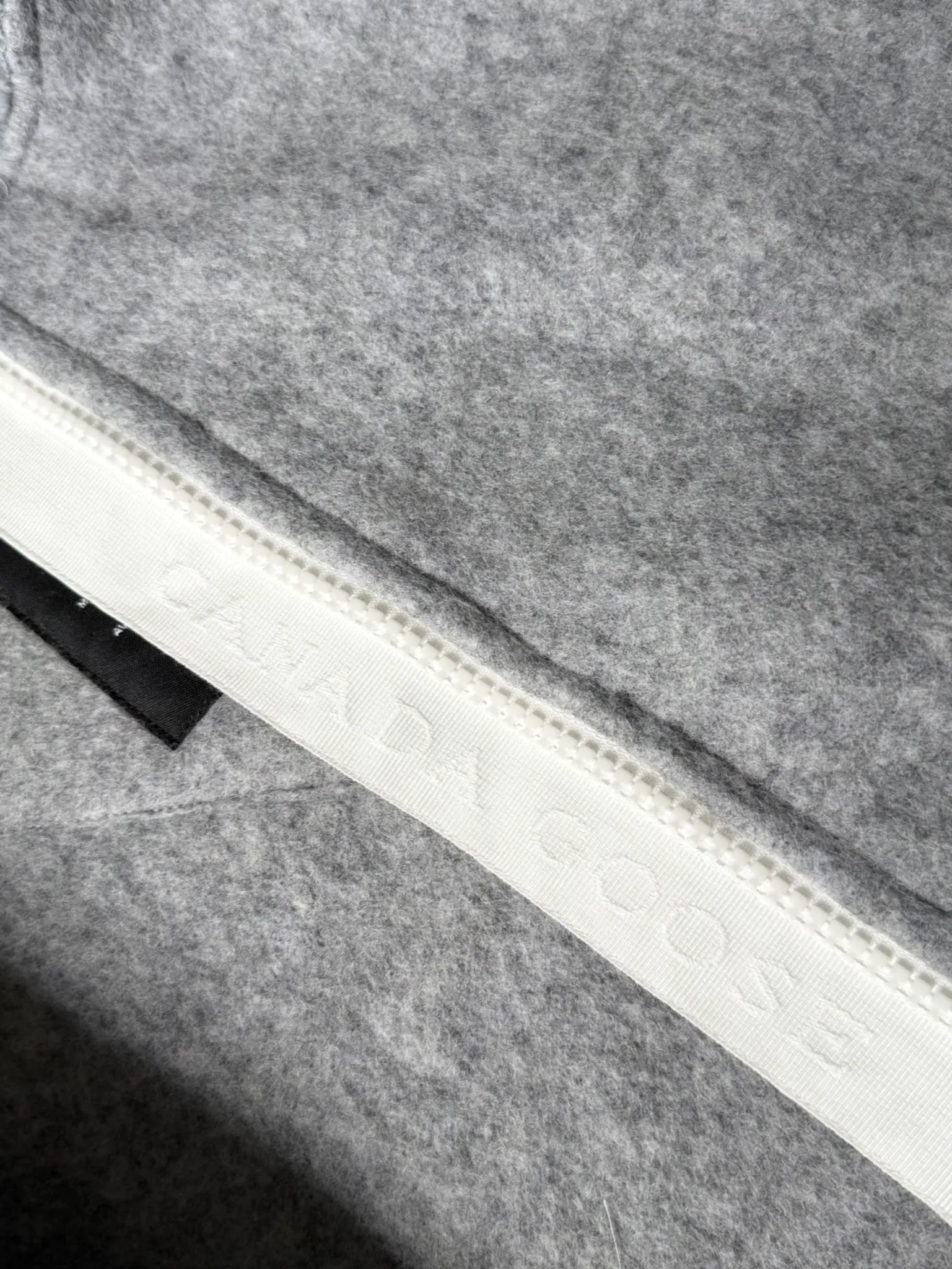 P660 Canada Goose Fleece Wool Badge Hooded Jacket Fabric selection: Wool fleece fabric blended with wool as the main body and a very small amount of spandex and polyester fiber. Wool is a core natural ingredient that provides unparalleled temperature regulation, antibacterial and anti-odor properties and a skin-friendly feel. The feeding of a small amount of spandex gives the fabric a certain degree of four-way elasticity, making it non-restrictive during daily activities. As the basis of fleece's structure, polyester fiber enhances the fabric's durability, wrinkle resistance and quick-drying properties. It contributes to the loft of the fleece and provides functions such as trapping air.  Detail 1: The sleeves and hem are closed with 2×2 ribbing. Its strong elasticity can closely fit wrists and waists of different thicknesses, forming an effective 'seal' to prevent cold wind from blowing back. It can still maintain its original shape after repeated stretching and use, and is not easy to loose and deform. And the ribbed cuffs can convey a sense of design and enhance the visual beauty.  Detail 2: The combination of hood design and elastic buckle improves warmth and windproof performance when wearing. Accessories: Customized elastic drawstring, elastic buckle, custom zipper pendant, custom armband Size: S M L Color: black gray coffee rice pink